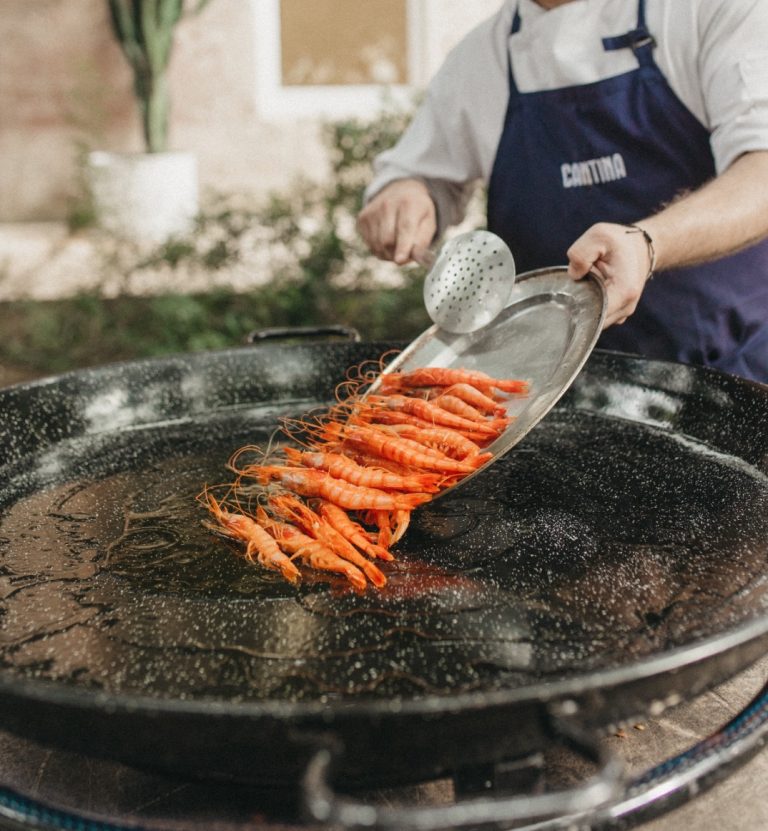 Prawns going into a pan for seafood paella